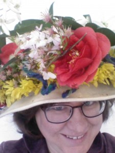 Kathryn wearing glasses and a pale hate with white, pink and yellow flowers 